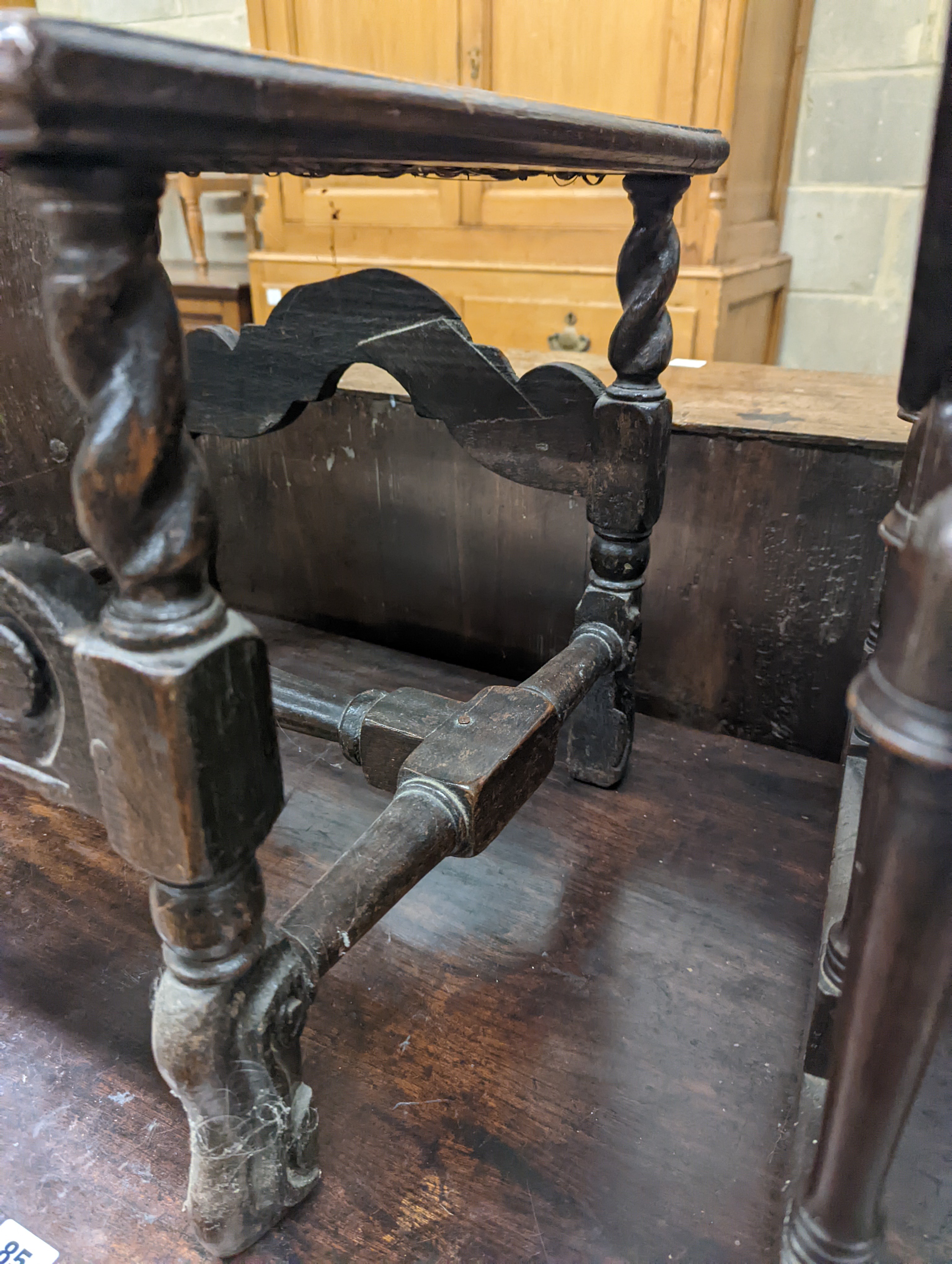 A 17th century style carved oak stool, with caned seat and H stretcher, width 47cm, depth 46cm, height 42cm